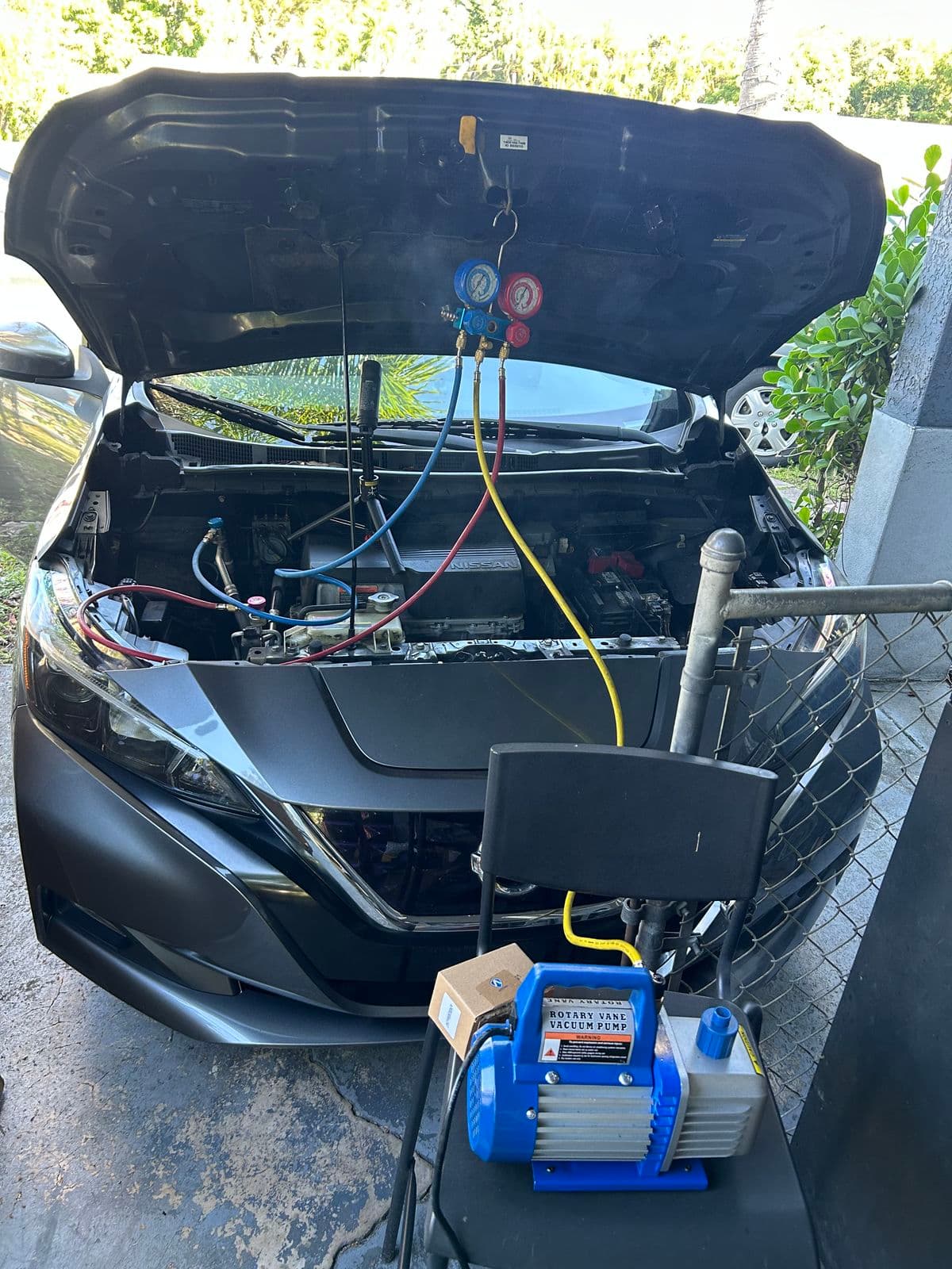 Car air-conditioning gauges connected at an open hood