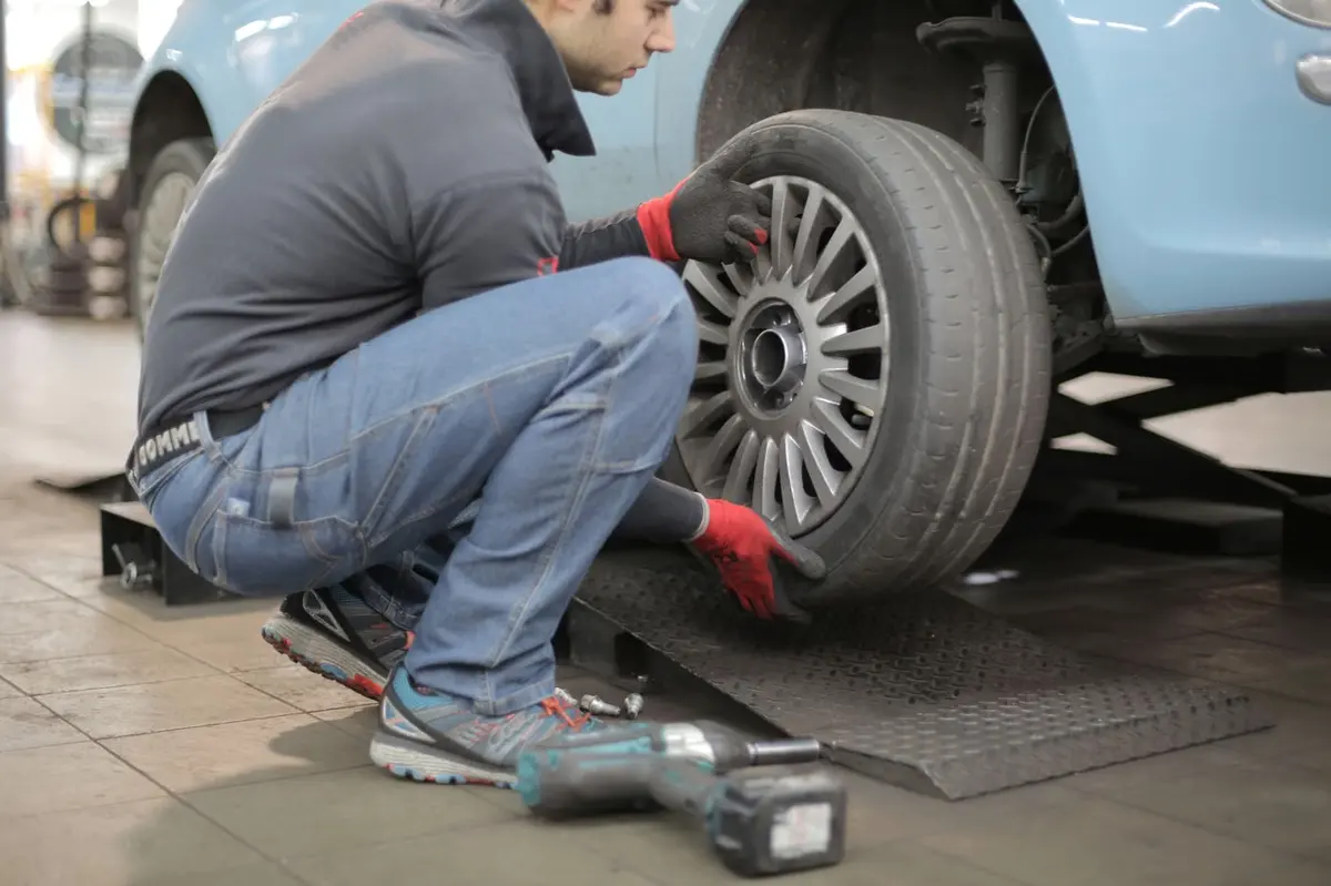 Technician working at a car wheel